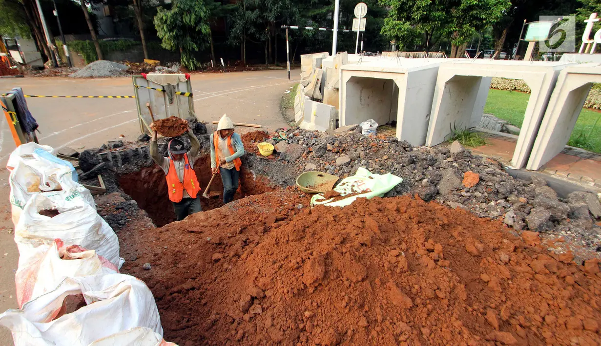 Pekerja menggali lubang untuk pengerjaan penataan jalur pedestrian di Jalan Sisingamangaraja, Jakarta Selatan, Jumat (4/5). Perbaikan tersebut untuk memperlancar aliran air saat musim penghujan tiba. (Liputan6.com/JohanTallo)