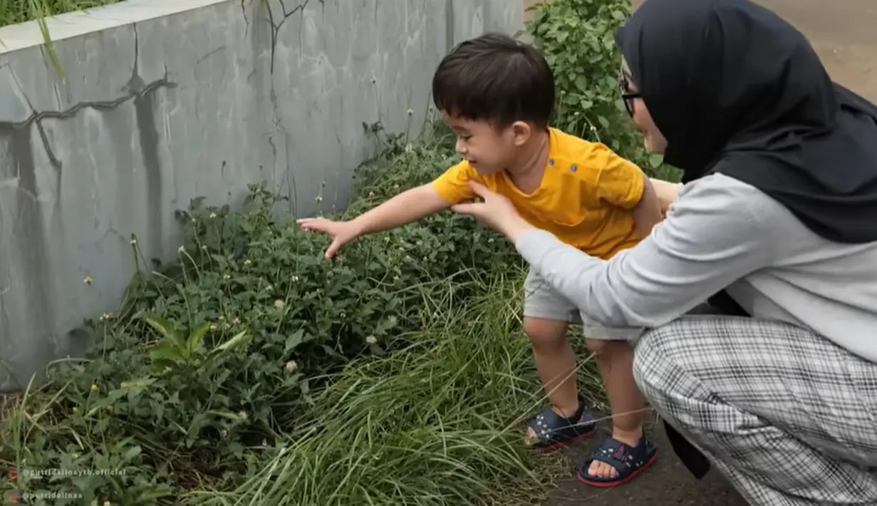 Tidak hanya Putri, Adzam juga terlihat begitu senang saat diajak main keluar rumah. [Youtube/Putri Delina AS]