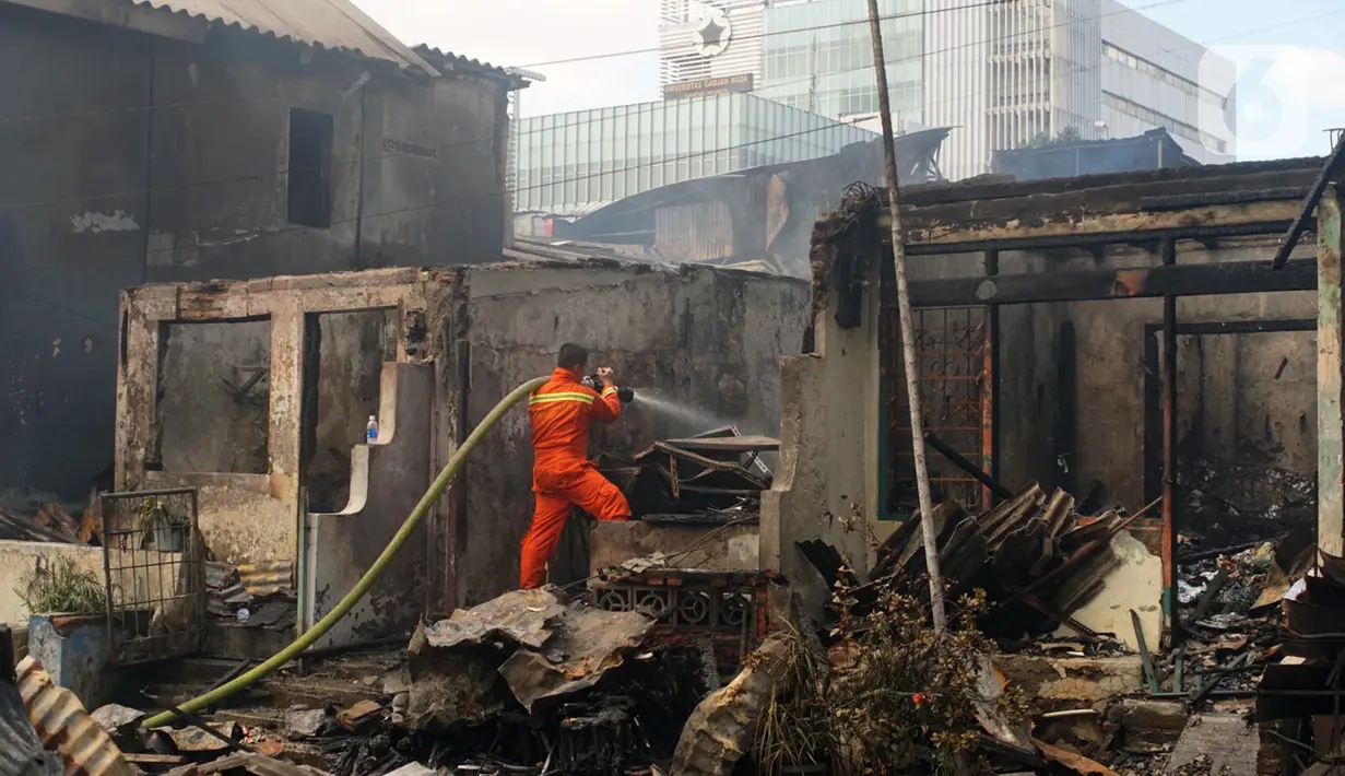 Petugas berusaha memadamkan sisa api yang membakar toko dan pemukiman warga di kawasan Manggarai, Jakarta, Selasa (7/7/2020). Hingga kini belum diketahui pengebab kebakaran. (Liputan6.com/Immanuel Antonius)