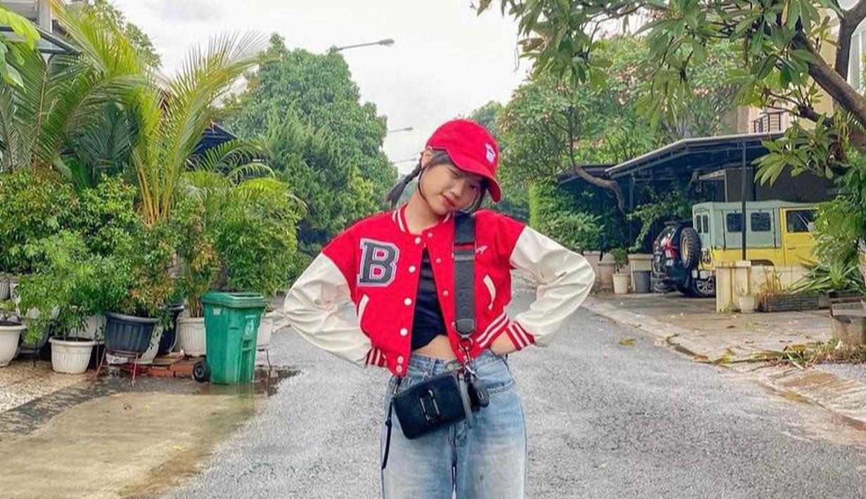 Boyfriend jeans dan crop baseball jacket berwarna merah putih bisa menjadi pilihan. Semakin kece dengan tambahan topi dan sling bag seperti adik ipar mendiang Vanessa Angel, Fuji. (Instagram/fuji_an).