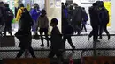 Orang-orang yang mengenakan masker untuk mengekang penyebaran virus corona COVID-19 berjalan melewati stasiun kereta api di Tokyo, Jepang, Rabu (6/1/2021). Ibu kota Jepang itu mengkonfirmasi lebih dari 1.500 kasus baru virus corona COVID-19 pada 6 Januari 2021. (AP Photo/Eugene Hoshiko)