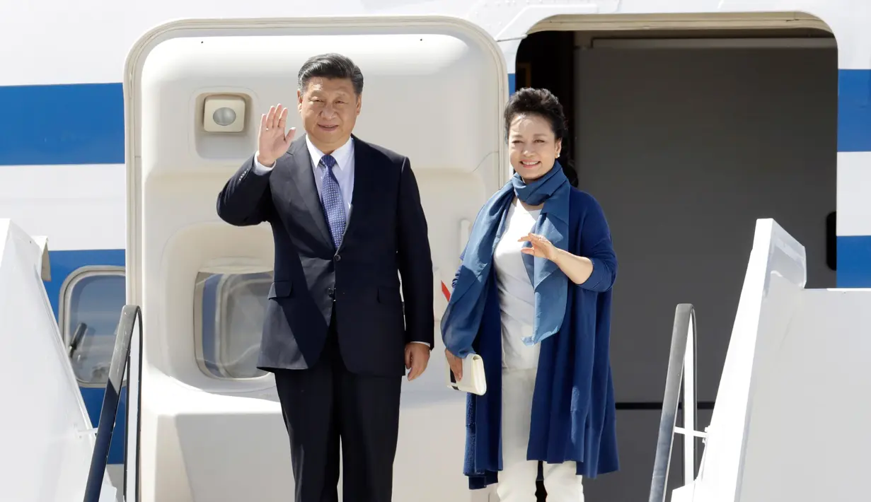 Presiden China Xi Jinping dan istrinya, Peng Liyuan melambaikan tangan setibanya di Hamburg, Jerman, Kamis (6/7). Sejumlah kepala negara telah tiba di Hamburg jelang pembukaan KTT G20 pada 7-8 Juli 2017. (AP/Michael Sohn)