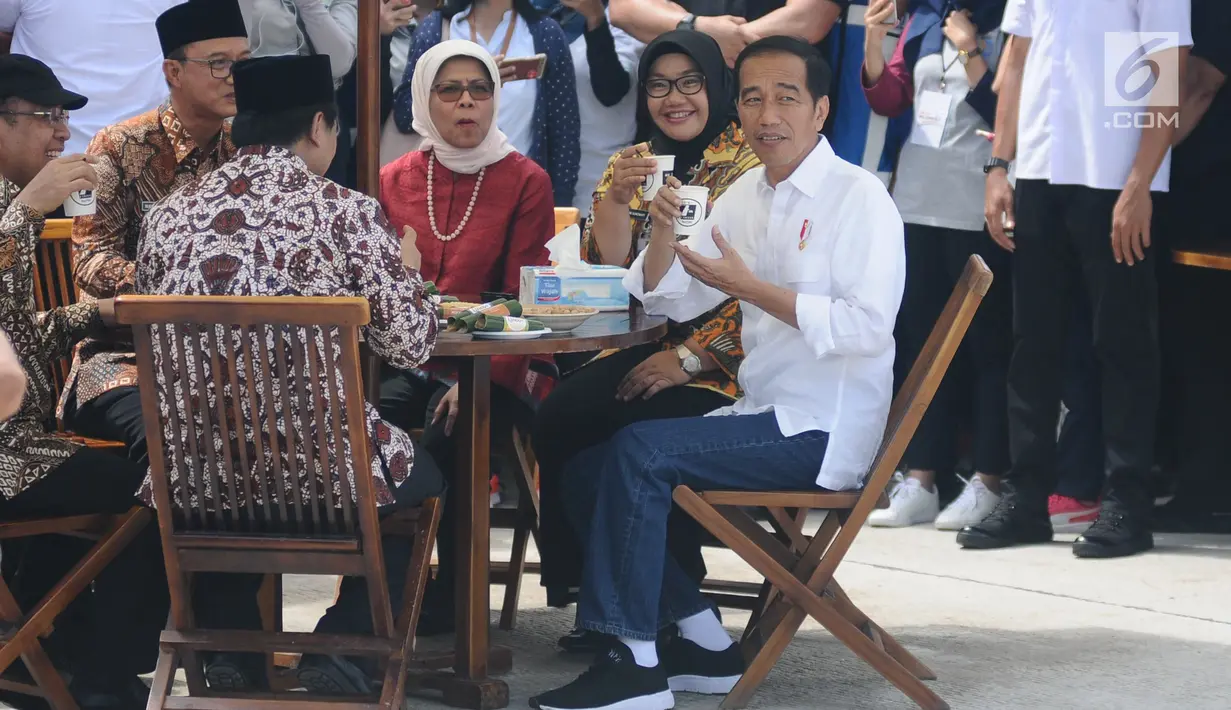 Presiden Joko Widodo (Jokowi) menikmati minuman saat meninjau Rest Area 538 dan menjajal makanan seusai meresmikan ruas  Tol Sragen-Ngawi, Rabu (28/11). Jokowi duduk semeja dengan kepala serta pimpinan daerah setempat. (Liputan6.com/Angga Yuniar)
