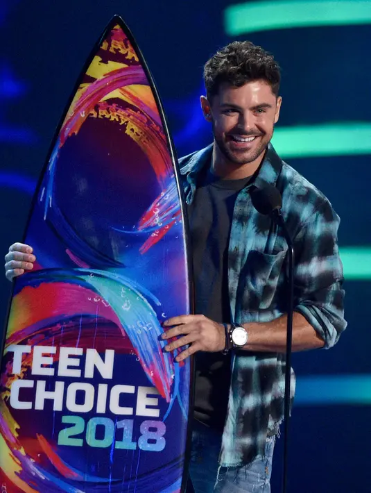 Aktor Zac Efron menerima penghargaan untuk kategori Aktor Drama Terbaik dalam film The Greatest Showman pada acara Teen Choice Awards di California, 12 Agustus 2018. Zac terlihat kece dengan gaya kasual serta rambut cepaknya. (Chris Pizzello/Invision/AP)