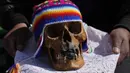 Seseorang membawa tengkorak manusia untuk diberkati oleh seorang imam selama Festival Natitas di Pemakaman Umum di La Paz, Bolivia, Selasa (8/11/2022). Tradisi tahunan ini merayakan kematian di Bolivia dengan tengkorak yang dirawat dan didekorasi oleh mereka yang menggunakannya sebagai jimat untuk perlindungan. (AP Photo/Juan Karita)