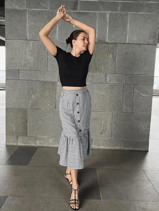 Padu padan outfit monokrom kerap jadi andalan. Padu padan crop top dan plaid skirt pun bikin ia terlihat bak ABG. (Instagram/dagnesia).