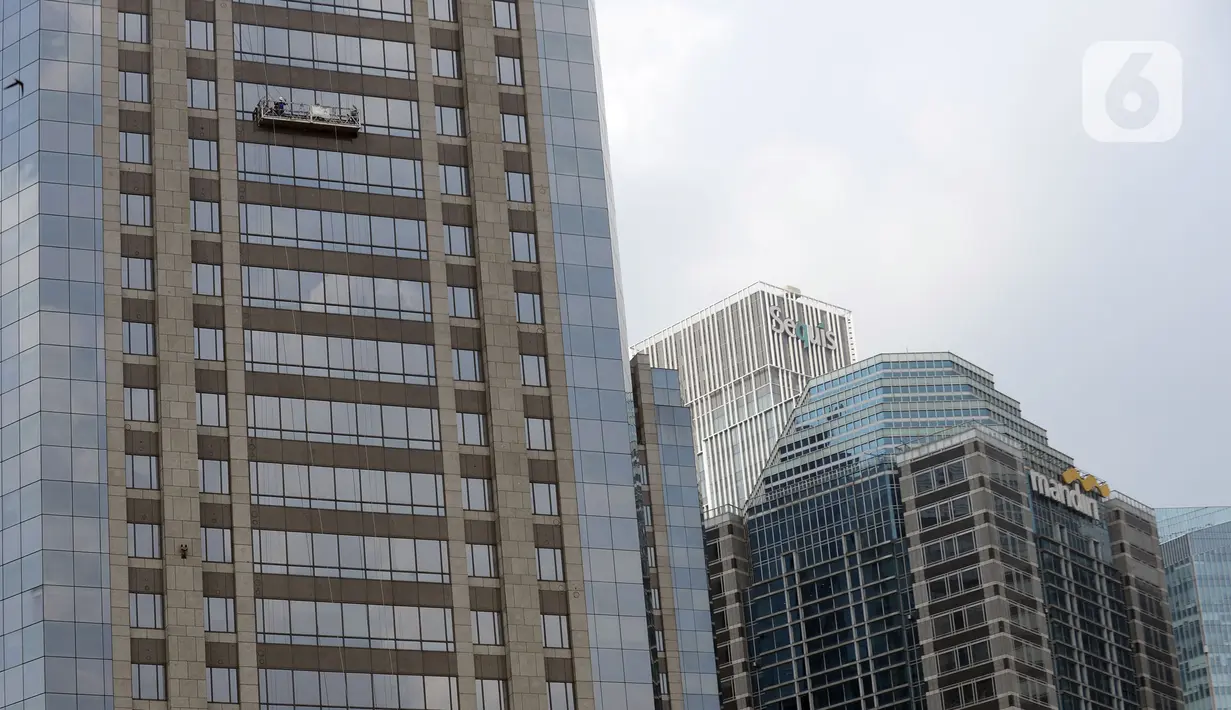 Pekerja membersihkan kaca gedung bertingkat di kawasan Sudirman Central Business District (SCBD), Jakarta, Senin (8/6/2020). Hampir tiga bulan kebijakan work from home (WFH) akibat pandemi COVID-19, banyak gedung bertingkat tidak terawat hari ini mulai dibersihkan. (merdeka.com/Dwi Narwoko)