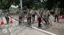 Polisi memasang kawat berduri saat peringatan May Day di depan Istana Negara, Jakarta, Senin (1/5). Istana Negara menjadi titik konsentrasi puluhan ribu buruh yang memperingati Hari Buruh Internasional. (Liputan6.com/Gempur M Surya)