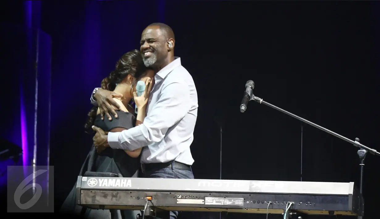 Penyanyi Raisa menutup mata sambil tersenyum dan disambut pelukan oleh penyanyi idolanya, Brian McKnight, seusai berkolaborasi dalam gelaran konser "The 90s Soul Ace" di kawasan Kasablanka, Jakarta, Kamis (8/12). (Liputan6.com/Herman Zakharia)