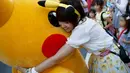 Seorang wanita memeluk Pikachu dalam serial animasi Pokemon melakukan parade di Yokohama , Jepang , 7 Agustus 2016. (REUTERS / Kim Kyung - Hoon)