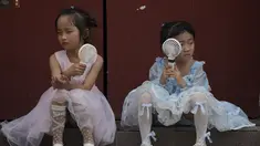 Anak-anak mendinginkan diri dengan kipas angin listrik saat beristirahat dekat Kota Terlarang pada hari yang panas di Beijing, China, 25 Juni 2023. Beijing meningkatkan level peringatan cuaca panas menjadi level tertinggi, yaitu kode merah. (AP Photo/Andy Wong)