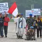 Aksi Anggota Polisi Militer Angkatan Darat IV/Surakarta Kopral Partika Subagyo Lelono (53) di Tugu Monas, Jakarta, Jumat (17/6). Kopral Bagyo juga didampingi beberapa orang sambil membawa atribut bertulisan bahaya narkoba. (Liputan6.com/Gempur M Surya)