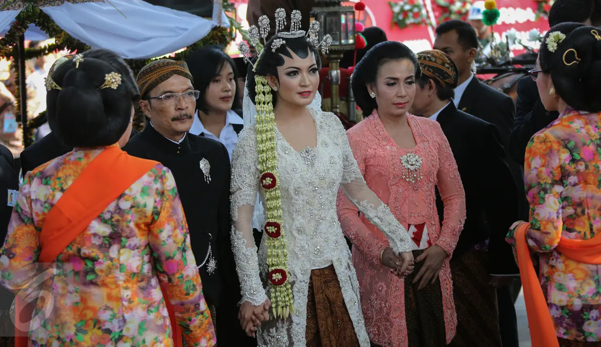 Dengan mengenakan kebaya putih dan didampingi kedua orangtuanya, Selvi Ananda (tengah) tiba di Gedung Graha Saba Buana untuk menjalani prosesi akad nikah, Solo, Jawa Tengah, Kamis (11/6/2015). (Liputan6.com/Faizal Fanani) 