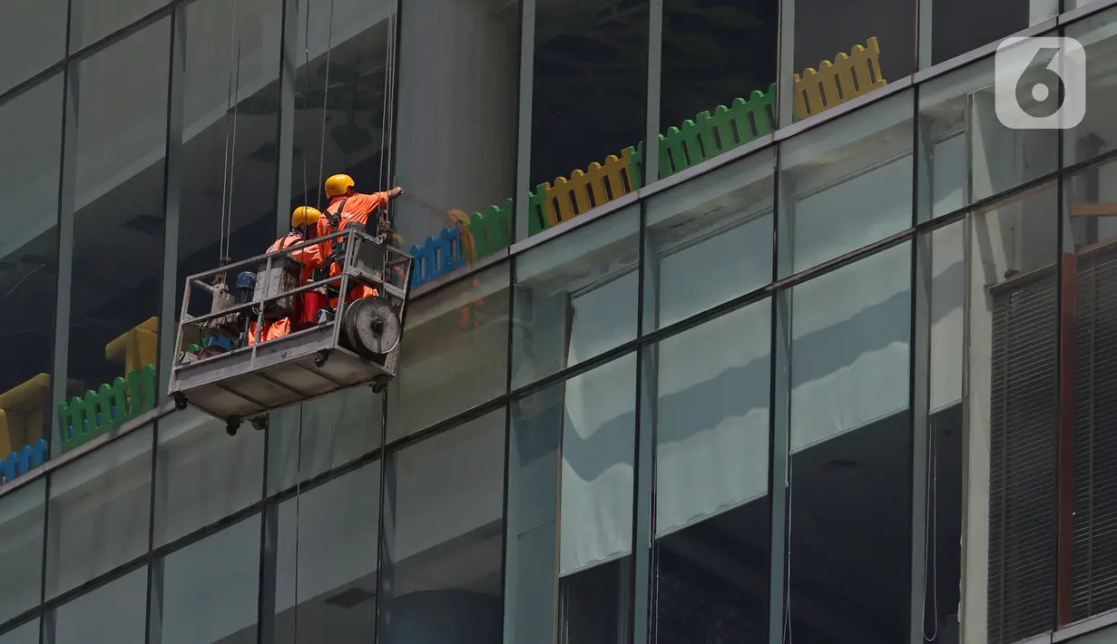 Pekerja membersihkan kaca gedung bertingkat di kawasan Jakarta, Kamis (2/4/2020). Dari 128 juta angkatan kerja di Indonesia, hanya 39% atau 50 jutaan pekerja yang terlindungi jaminan sosial ketenagakerjaan. (Liputan6.com/Herman Zakharia)