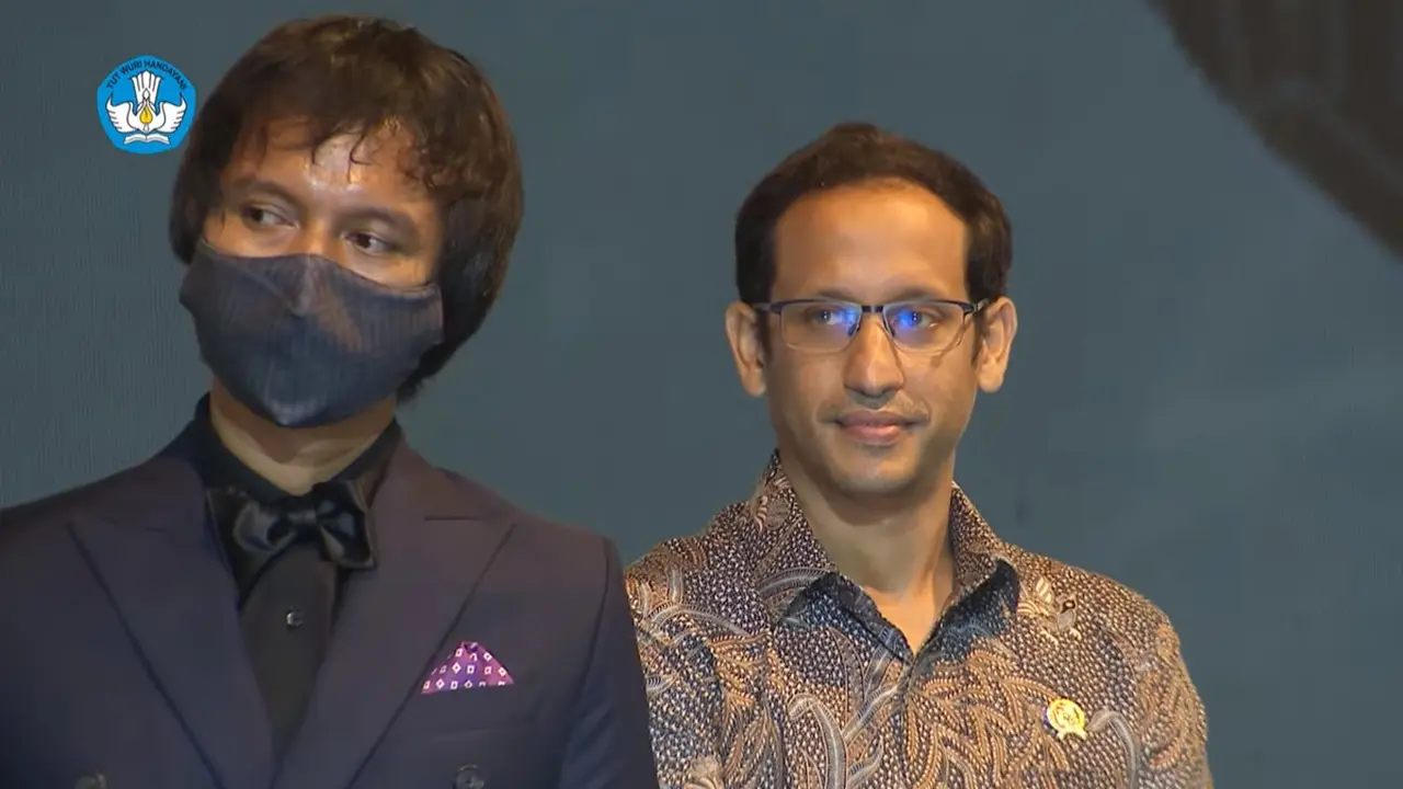 Penulis naskah Penyalin Cahaya, Henricus Pria, berdiri di sebelah Menteri Pendidikan Nadiem Makarim di Piala Citra 2021.