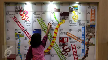 Seorang anak tengah bermain di wahana ular tangga di Kota Kasablanka, Jakarta (12/11). Pengunjung diajak bermain dan berpetualang di area 150 Years Nestle Story. (Liputan6.com/Fery Pradolo)