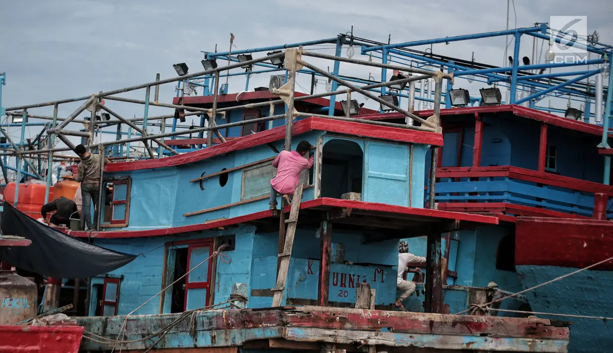 Sejumlah nelayan memperbaiki kapal di Pelabuhan Muara Angke, Jakarta, Kamis (27/12). Nelayan tidak bisa melaut akibat gelombang tinggi sejak sebulan belakangan. (Liputan6.com/Faizal Fanani)