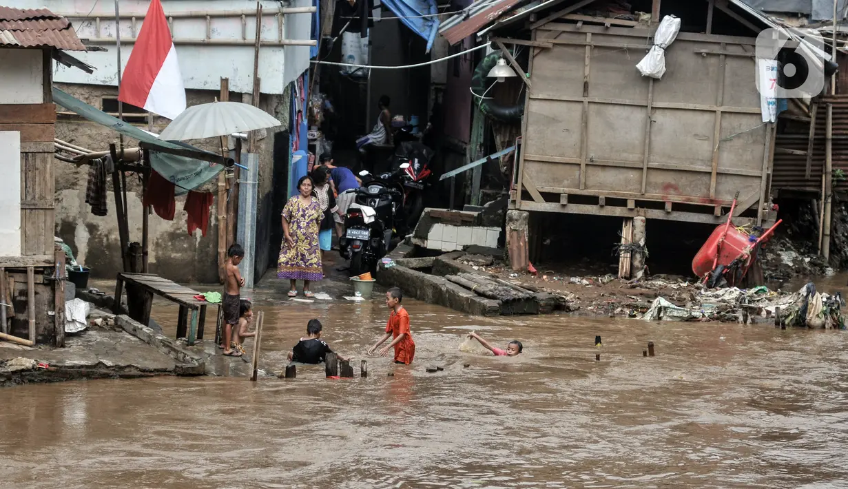 Anak-anak berenang di Kali Ciliwung yang meluap, Kebon Pala, Jatinegara, Jakarta Timur, Minggu (31/10/2021). Aliran Kali Ciliwung yang meluap akibat hujan di kawasan hulu dimanfaatkan anak-anak untuk berenang meski membahayakan keselamatan. (merdeka.com/Iqbal S. Nugroho)