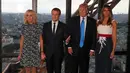 Presiden AS Donald Trump dan Melania serta Presiden Prancis Emmanuel Macron dan Brigitte Macron berfoto sebelum jamuan makan malam di Menara Eifel, Paris, Kamis (13/7). Kunjungan Trump ke Paris merupakan undangan Macron. (Yves Herman/Pool Photo via AP)