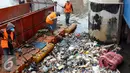Petugas dari Dinas Kebersihan mengangkut sampah yang tersangkut di Pintu Air, Jakarta, Jum'at (30/9). Perawatan Pintu Air dari tumpukan sampah yang tersangkut agar buka tutup pintu air Jembatan Hanging dapat maksimal. (Liputan6.com/Johan Tallo)