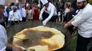 Proses penggorengan Bhatura dengan ukuran tak biasa di India, New Delhi, Kamis (6/4). Penyelenggara berharap Bhatura buatan mereka bisa memecahkan rekor Bhatura  terbesar di India. (AFP PHOTO / SAJJAD HUSSAIN)