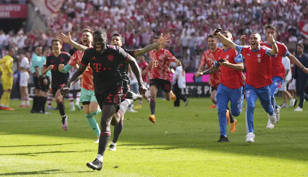 Para pemain Bayern Munchen berlari ke dalam lapangan merayakan kemenangan 2-1 atas FC Cologne pada laga pekan terakhir Liga Jerman 2022/2023 di Cologne, Jerman (27/5/2023). Kemenangan ini memastikan Bayern Munchen merebut gelar Liga Jerman 2022/2023. (AP Photo/Matthias Schrader)