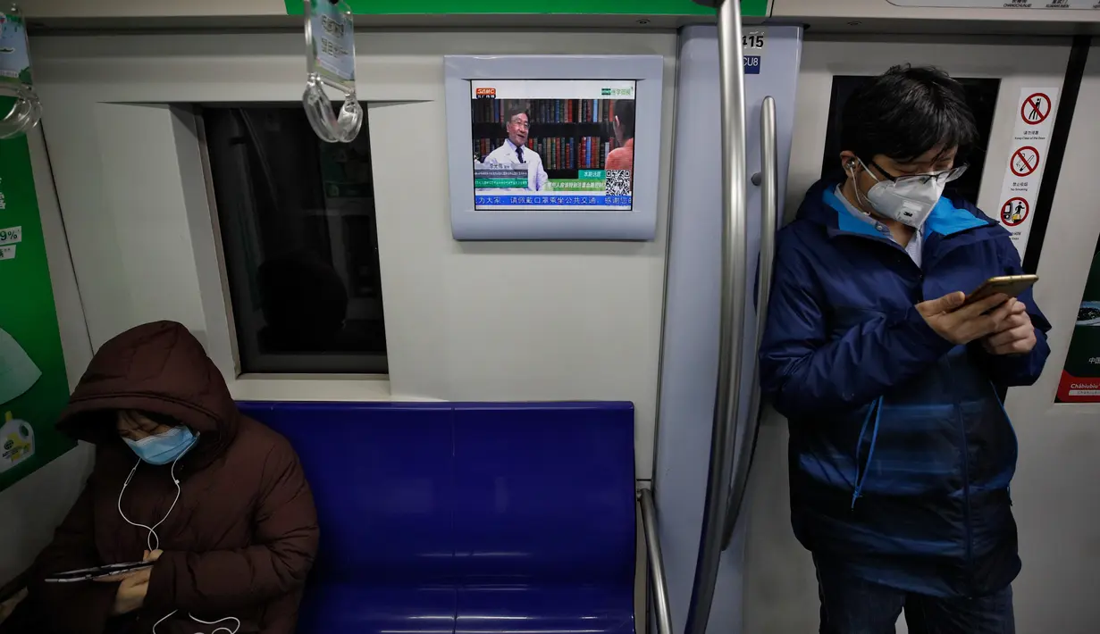 Para komuter mengenakan masker saat menaiki kereta bawah tanah di Beijing, China, Senin (17/2/2020). Wabah virus corona atau COVID-19 membuat warga Beijing beraktivitas menggunakan masker pelindung untuk mencegah terinfeksi virus yang telah menewaskan 1.770 orang tersebut. (AP Photo/Andy Wong)