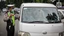 Petugas kepolisian memeriksa kelengkapan surat pengendara di pos cekpoin penyekataan arus mudik di kawasan Pasar Jumat, Kamis (6/5/2021). Penyekatan dan cek poin dilakukan saat penerapan larangan mudik Lebaran 2021 sebagai upaya pencegahan penularan COVID-19. (Liputan6.com/Faizal Fanani)