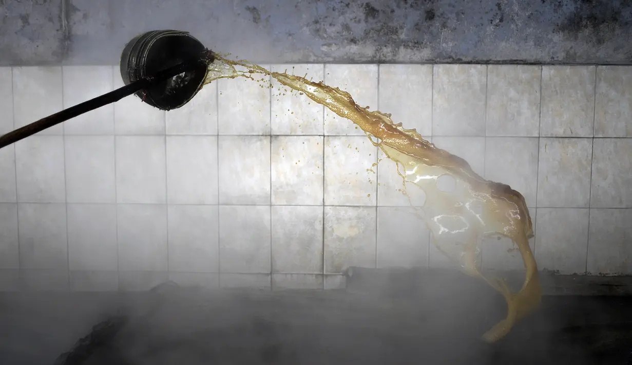 Seorang pekerja tebu memasak gula di trapiche panelero di Merida, Venezuela (21/9/2020). Jus tebu dibuat menjadi gula tebu utuh yang tidak dimurnikan yang dikenal sebagai panela, yaitu sukrosa berbentuk padat yang berasal dari perebusan dan penguapan sari tebu. (AP Photo/Matias Delacroix)