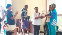 Mama Kristina saat membagikan buku saku bahasa Malind di SD Don Bosco Merauke. (Foto: Liputan6.com/Katharina Lita)
