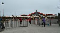 Petugas Bandara Sentani di Kabupaten Jayapura menutup pintu masuk dan keluar bandara. Hal ini diberlakukan hingga 14 hari kedepan untuk penghentian sementara penerbangan penumpang. (Liputan6.com/Katharina Janur/Findi)