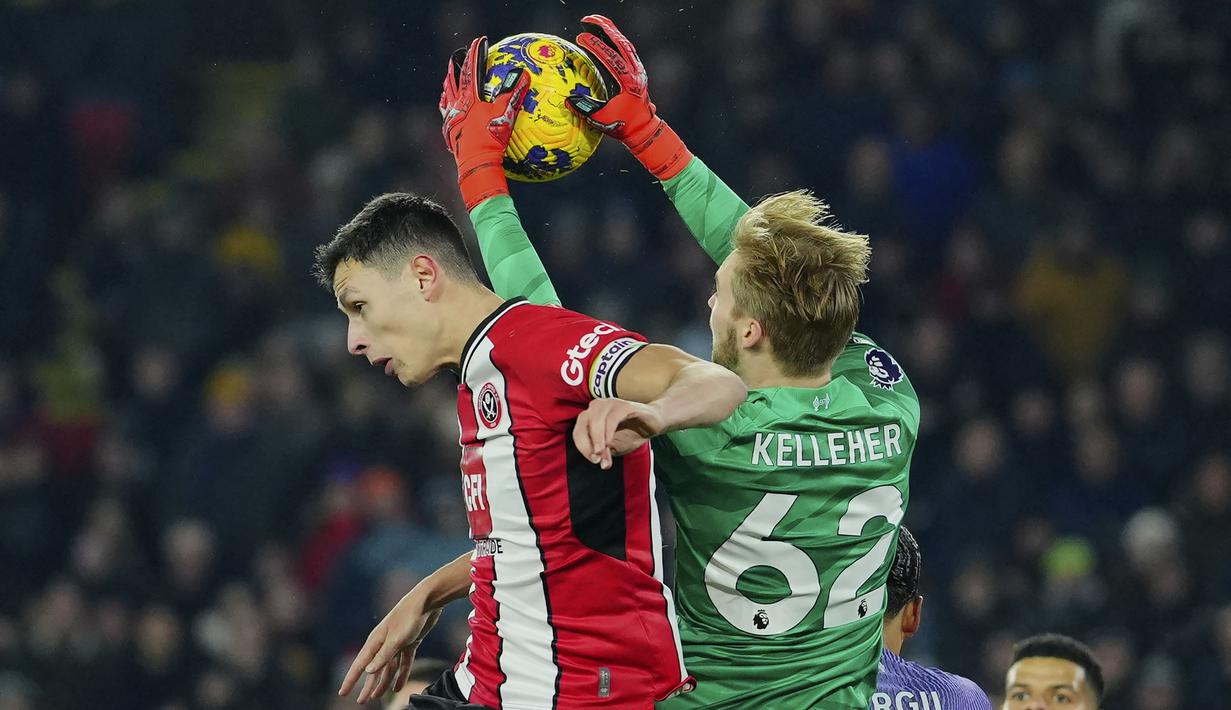Kiper Liverpool, Caoimhin Kelleher (kanan) berhasil menangkap bola dari ancaman bek Sheffield United, Anel Ahmedhodzic pada laga pekan ke-15 Liga Inggris 2023/2024 di Bramall Lane, Sheffield, Kamis (7/12/2023) dini hari WIB. (AP Photo/Jon Super)