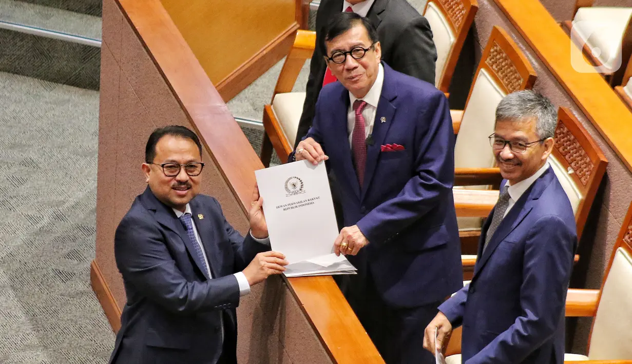 Wakil Ketua Komisi III DPR Pangeran Khaerul Saleh menyerahkan hasil pendapat fraksi kepada Menteri Hukum dan Hak Asasi Manusia Yasonna H Laoly saat rapat Paripurna DPR RI Ke-13 Masa Persidangan II Tahun Sidang 2022-2023, Kamis (15/12/2022). DPR RI mengesahkan RUU tentang Pengesahan Perjanjian antara Pemerintah Republik Indonesia dan Pemerintah Republik Singapura tentang Ekstradisi Buronan menjadi Undang-Undang. (Liputan6.com/Angga Yuniar)