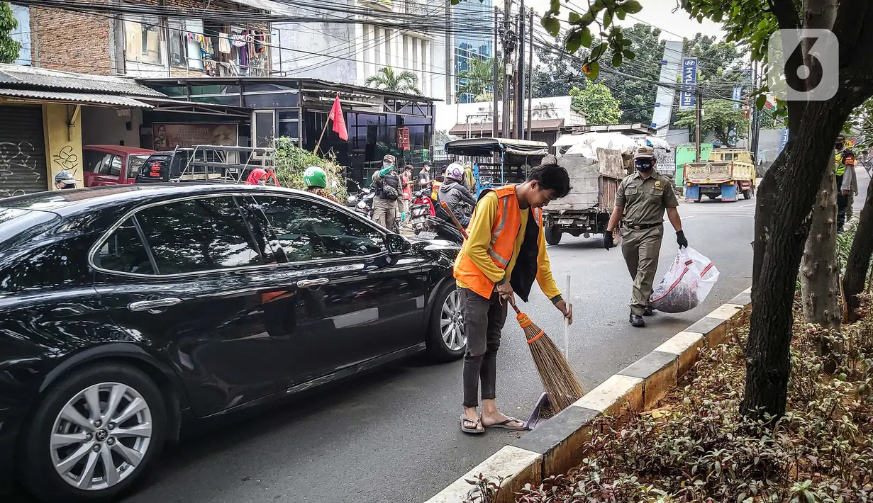 Warga menyapu jalan saat terkena razia masker di kawasan Karang Tengah Raya, Lebak Bulus, Jakarta, Senin (14/9/2020). Penertiban terkait pelaksanaan PSBB Jakarta kembali dan memutus rantai penyebaran COVID 19. (Liputan6.com/Faizal Fanani)
