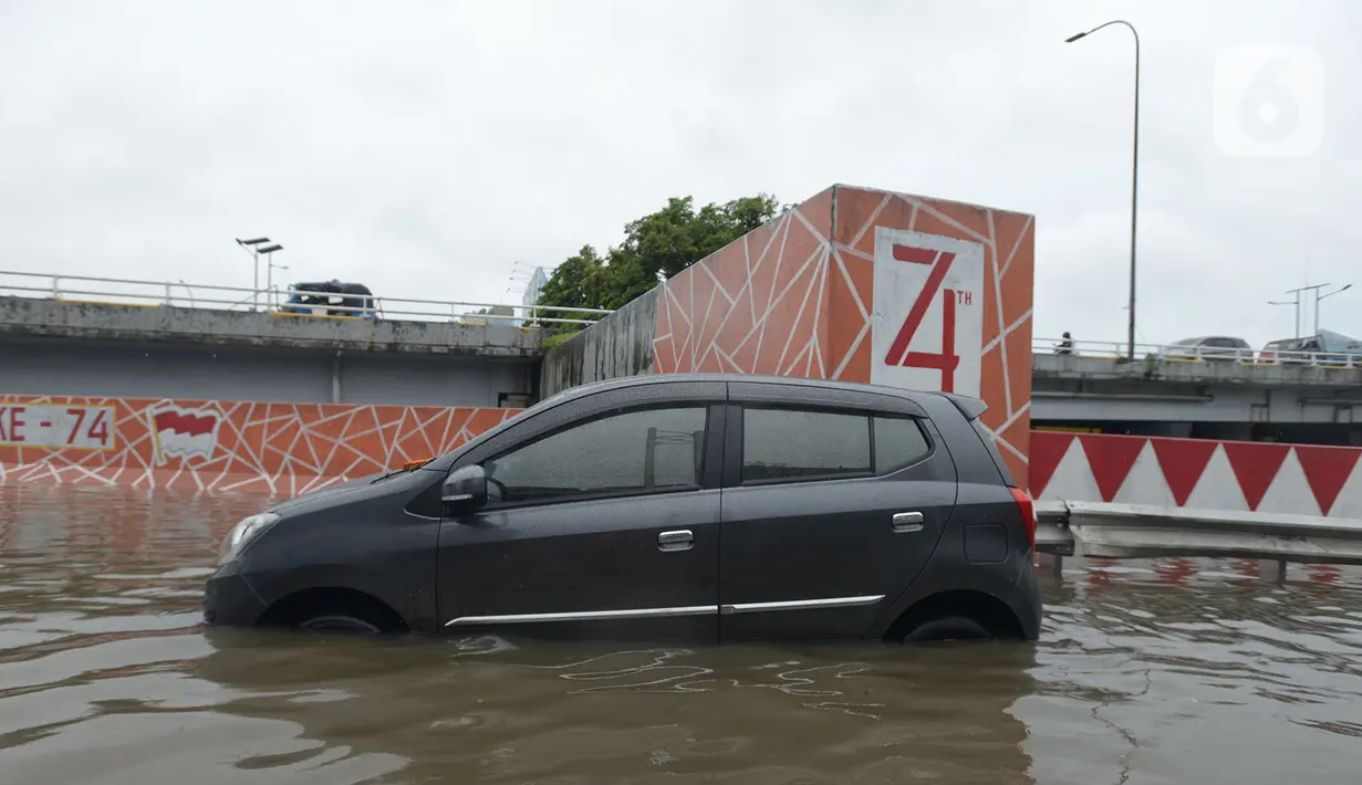 Sebuah mobil melintasi banjir di Jalan Raya Daan Mogot, Jakarta, Rabu (1/1/2020). Hujan yang turun saat malam pergantian tahun baru 2019-2020 menyebabkan sejumlah titik jalan terputus di kawasan Grogol terendam banjir. (merdeka.com/Imam Buhori)