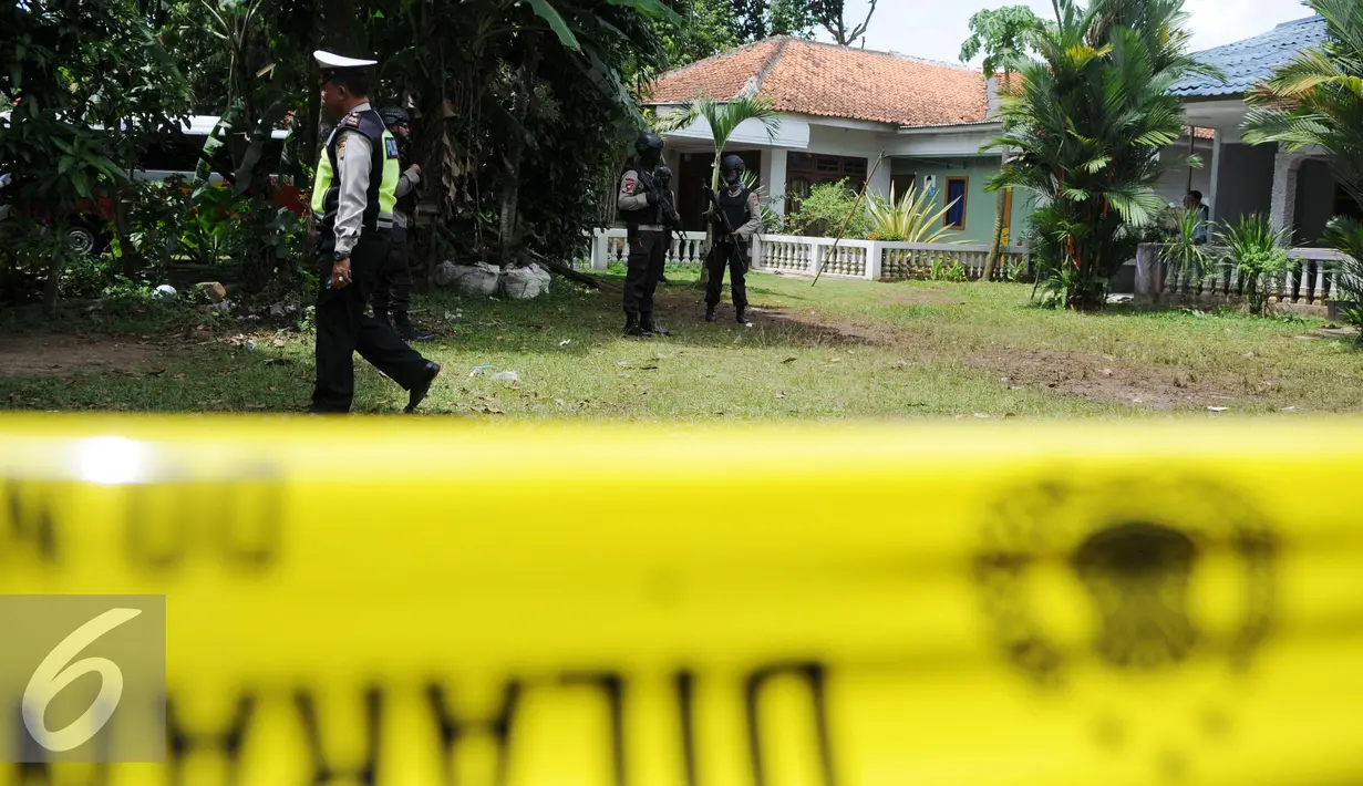 Petugas Kepolisian Brimob Polda Metro Jaya berjaga disekitar area rumah terduga teroris di Setu, Tangerang Selatan, Rabu (21/12). Tim Densus Anti Teror 88 berhasil melumpuhkan empat orang terduga teroris.(Liputan6.com/Helmi Affandi)