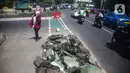 Pejalan kaki melintas di samping jalur sepeda yang di bongkar di kawasan Cikini, Jakarta, Selasa (19/11/2019). Jalur sepeda berumur 2 bulan tersebut dibongkar akibat proyek pelebaran trotoar. (Liputan6.com/Faizal Fanani)