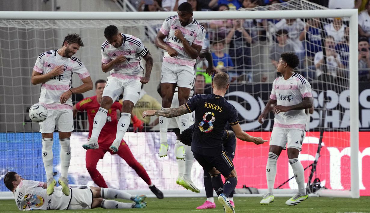Pemain Real Madrid, Toni Kroos (tengah) melakukan tendangan bebas dihalau pemain Juventus pada laga uji coba pramusim di Camping World Stadium, Orlando, Florida, Amerika Serikat, Kamis (03/08/2023) WIB. (AP Photo/John Raoux)