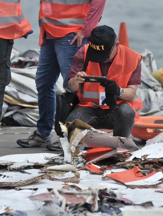 Penyelidik dari KNKT Amerika Serikat mengambil gambar puing-puing pesawat Lion Air JT 610 PK-LQP di Pelabuhan JICT 2, Jakarta, Kamis (1/11). Tim investigasi dari Amerika Serikat dibawa untuk membantu penyelidikan. (Merdeka.com/ Iqbal S. Nugroho)