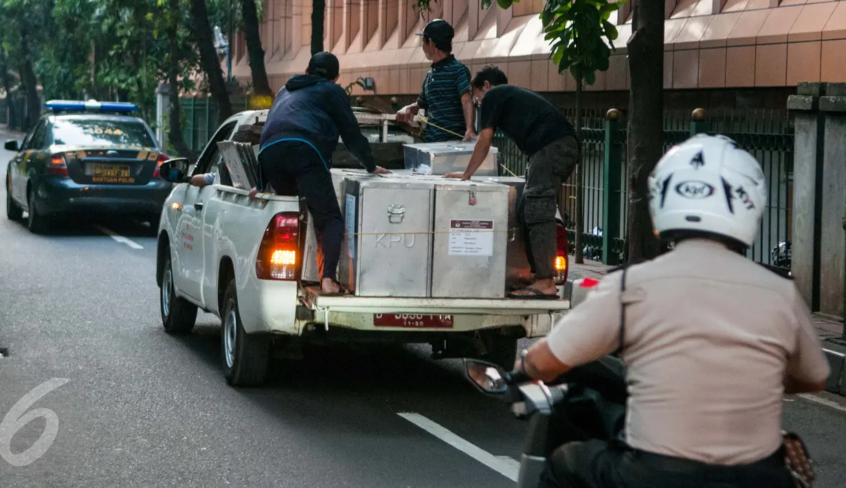 Petugas membawa kotak suara yang akan didistribusikan ke kelurahan di Kecamatan Menteng, Jakarta, Senin (17/4). Logistik surat suara Pemilihan Gubernur dan Wagub DKI telah siap didistribusikan ke kelurahan di Jakarta. (Liputan6.com/Gempur M Surya)