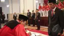 Manahan Malontige Pardamean Sitompul menandatangani surat pelantikan dirinya sebagai Hakim Konstitusi di Istana Negara disaksikan oleh Presiden Jokowi, Jakarta, Selasa (28/4/2015). (Liputan6.com/ Faizal Fanani)