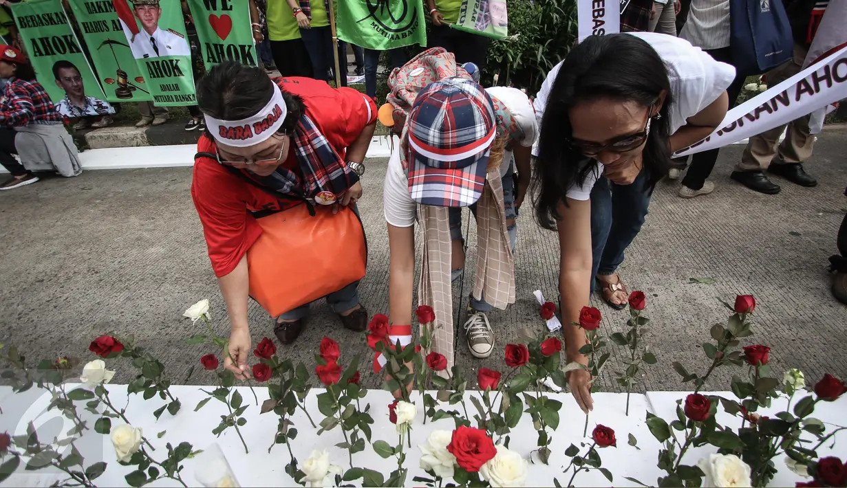 Massa melakukan aksi tancap bunga mawar merah dan putih di lokasi sidang vonis Basuki Tjahaja Purnama (Ahok) di Kementerian Pertanian, Jakarta, Selasa (9/5). Aksi itu diartikan sebagai bentuk rasa cinta pendukung kepada Ahok. (Liputan6.com/Faizal Fanani)