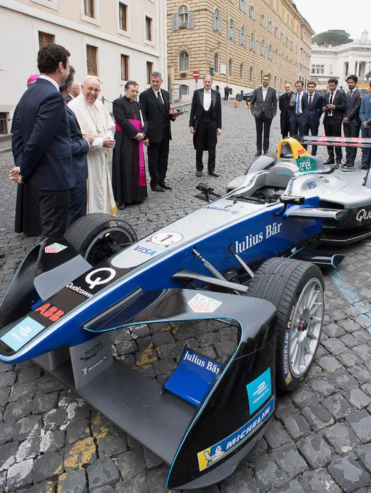 Paus Fransiskus melihat mobil balap listrik Formula E yang akan diberkati di Vatikan (11/4). Acara itu dihadiri pejabat tertinggi seri Formula E dan pembalap. (AFP Photo/Media Vatikan)