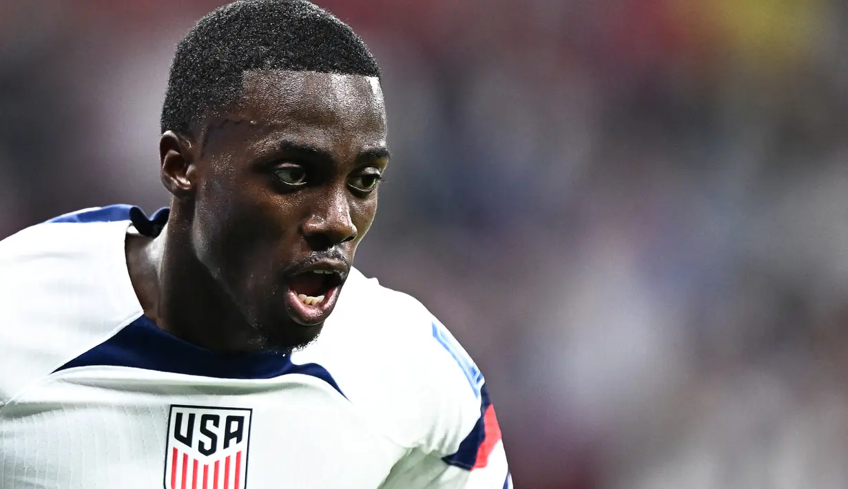 <p>Penyerang Timnas Amerika Serikat Timothy Weah melakukan selebrasi setelah mencetak gol pertama timnya pada pertandingan sepak bola Grup B Piala Dunia Qatar 2022 antara Amerika Serikat dan Wales di Stadion Ahmad Bin Ali di Al-Rayyan, Doha, Qatar, Senin (21/11/2022). Penampilan dan aksinya yang mampu mencetak gol melampaui impian George Weah yang belum sempat bermain di kompetisi tersebut. (Jewel SAMAD/AFP)</p>