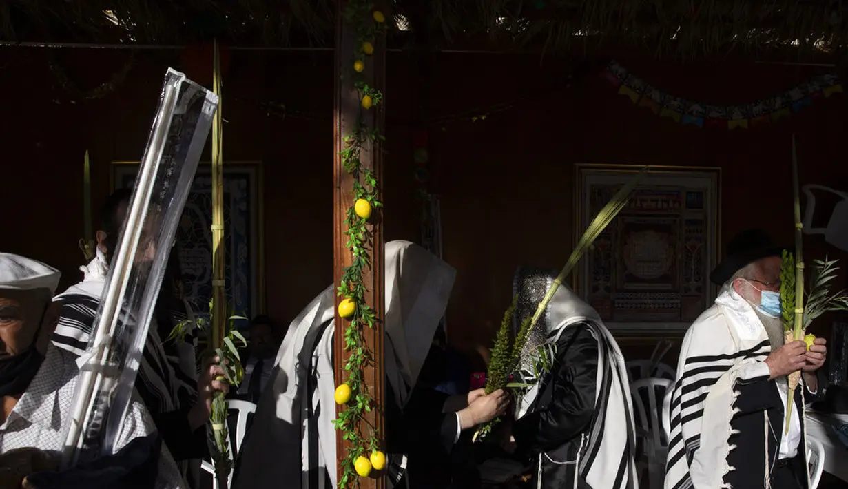 Pria Yahudi Ultra-Ortodoks berdoa selama hari raya Yahudi Sukkot di Tembok Barat, situs paling suci di mana orang Yahudi dapat berdoa di Kota Tua Yerusalem, Rabu (22/9/2021).  (AP Photo/Sebastian Scheiner)