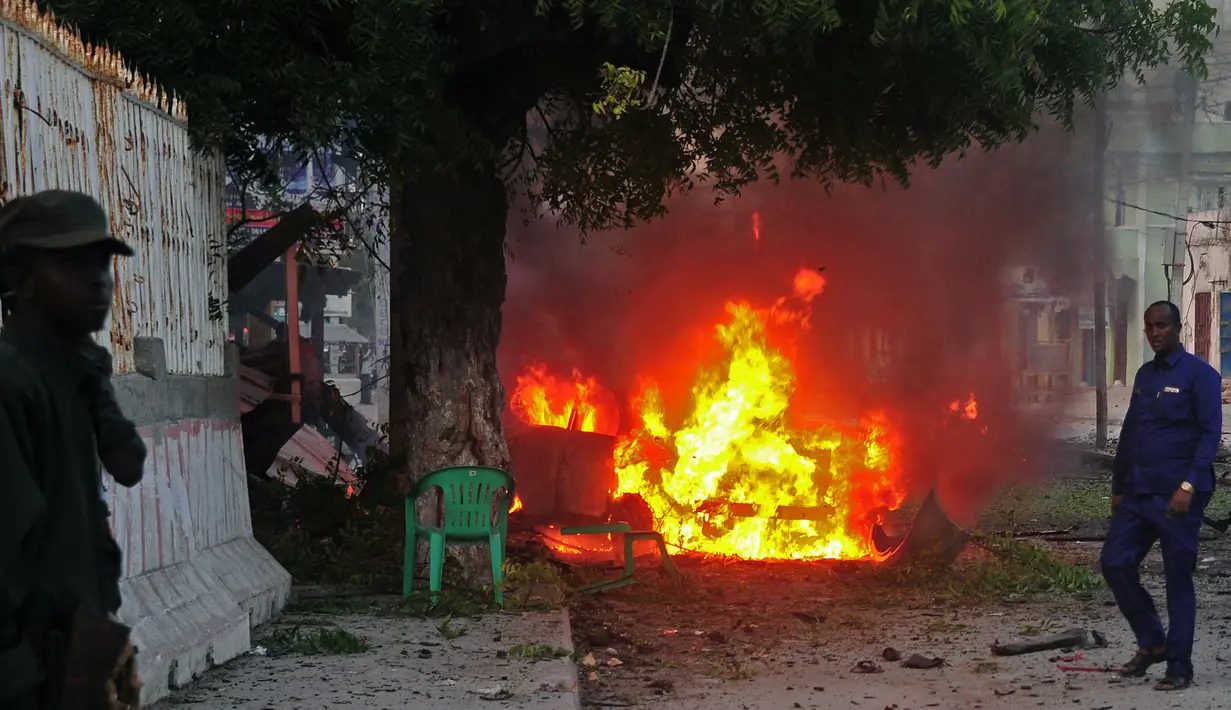 Sebuah mobil yang terbakar setelah sebuah serangan bom di sebuah restoran di Mogadishu, Somalia (8/5). Setidaknya 6 orang tewas dan 10 orang lainnya terluka dalam serangan bom mobil tersebut. (AFP Photo/Mohamed Abdiwahab)