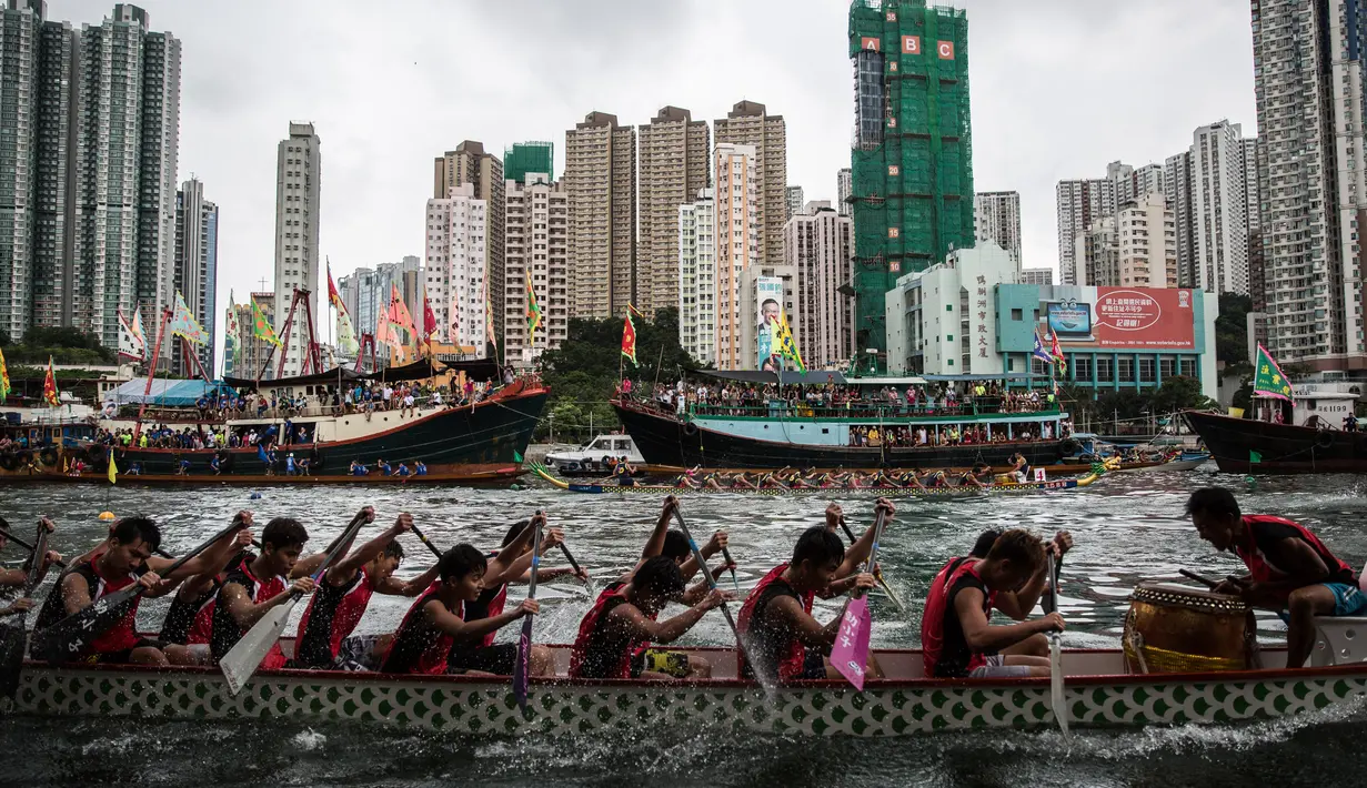 Peserta memacu perahu naga dalam peringatan tahunan Tuen Ng atau Festival Perahu Naga di Hong Kong, Kamis (9/6). Festival tersebut digelar tiap bulan kelima penanggalan Tiongkok. (Anthony WALLACE/AFP)