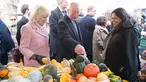 Pangeran Charles bersama istrinya, Duchess of Cornwall Camilla berbincang dengan pedagang ketika mengunjungi Swiss Cottage Farmers Market di London utara, Rabu (6/11/2019). Kunjungan Charles dan Camila untuk memperingati ulang tahun ke-20 pasar tersebut. (Eddie Mulholland / POOL / AFP)