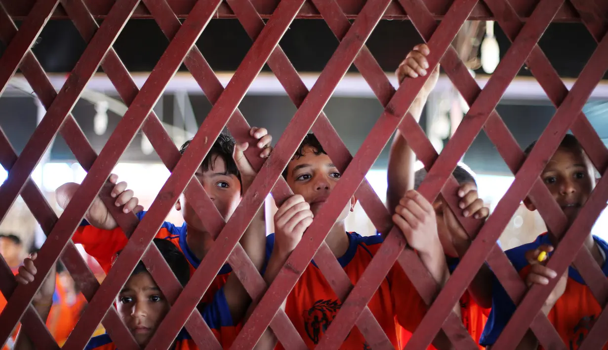 Sejumlah anak Palestina melihat peserta selama maraton lokal yang diselenggarakan oleh Culture and Free Thought association di Khan Younis di Jalur Gaza selatan (28/4/2016). (REUTERS / Ibraheem Abu Mustafa)