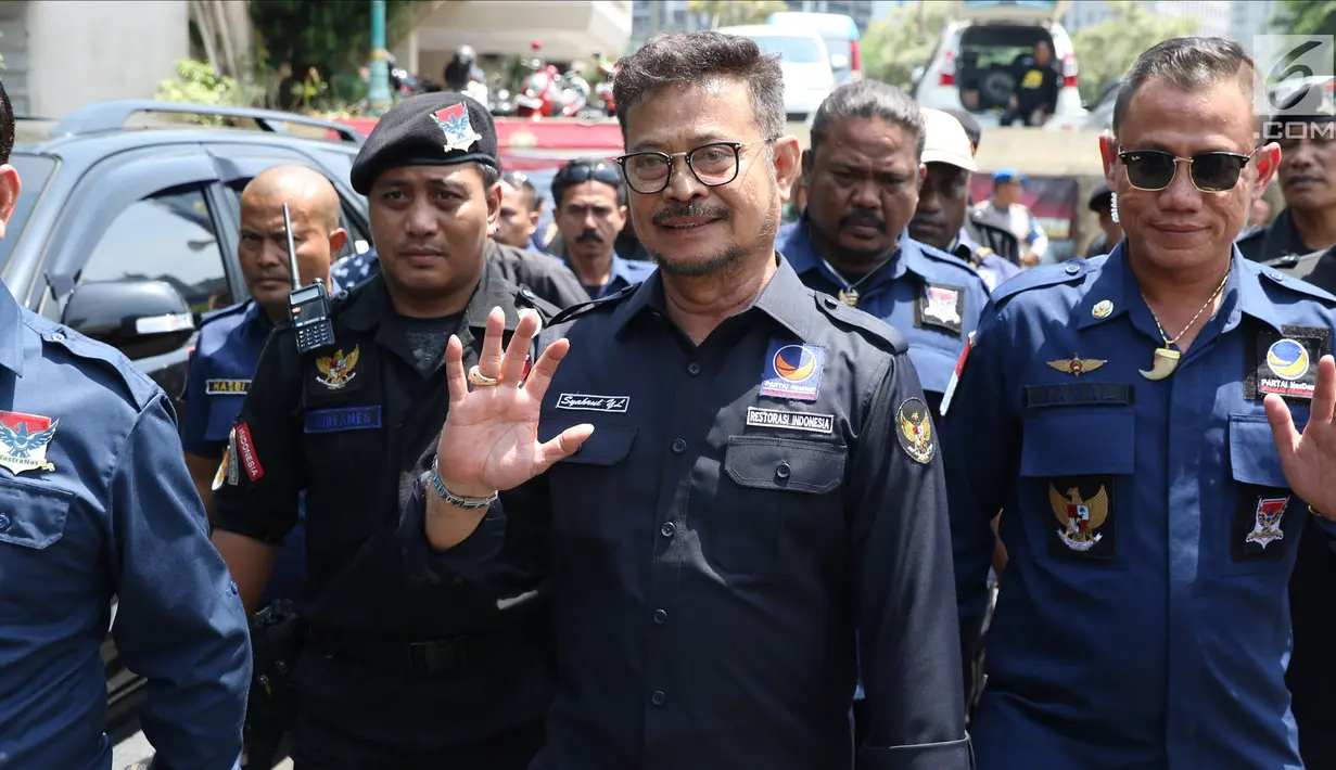 Ketua DPP NasDem Syahrul Yasin Limpo(tengah) bersama sejumlah kader Nasdem usai memberi keterangan terkait pelaporan dugaan pencemaran nama baikdi Sentra Pelayanan Kepolisian Terpadu Polda Metro Jaya, Senin (17/9). (Liputan6.com/Helmi Fithriansyah)